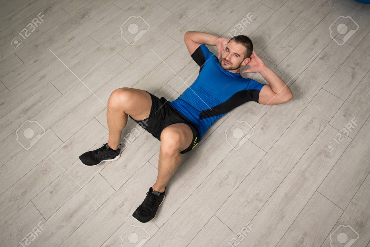 Personal Trainer Performing Abdominal Exercise On Floor One