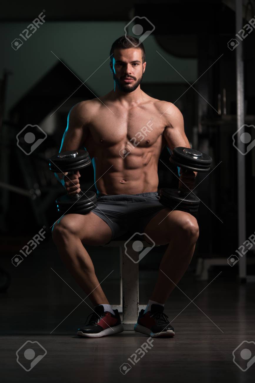 格好良いと筋肉を持つ魅力的な若い男体のベンチに座っているとジムでリラックス の写真素材 画像素材 Image