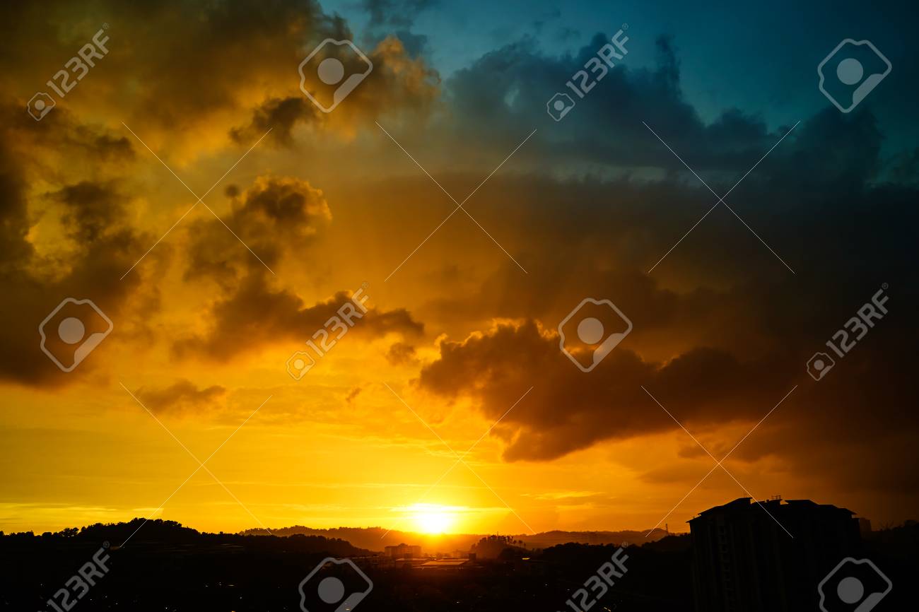 ドラマチックな青とオレンジ色の曇った夕日のゴールデンアワー の写真素材 画像素材 Image