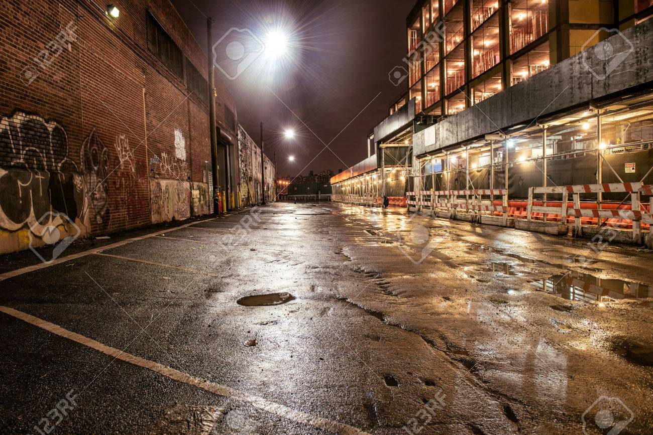 雨の後の夜の街でアスファルトを通り レンガの壁に落書きの駐車場 の写真素材 画像素材 Image
