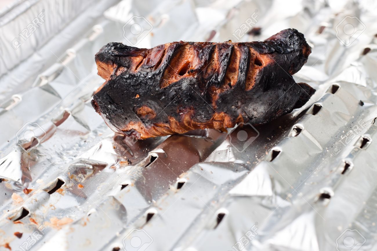 Detail of totally burnt sausage on tinfoil. - 10916615 Detail of totally burnt sausage on tinfoil. - 10916615