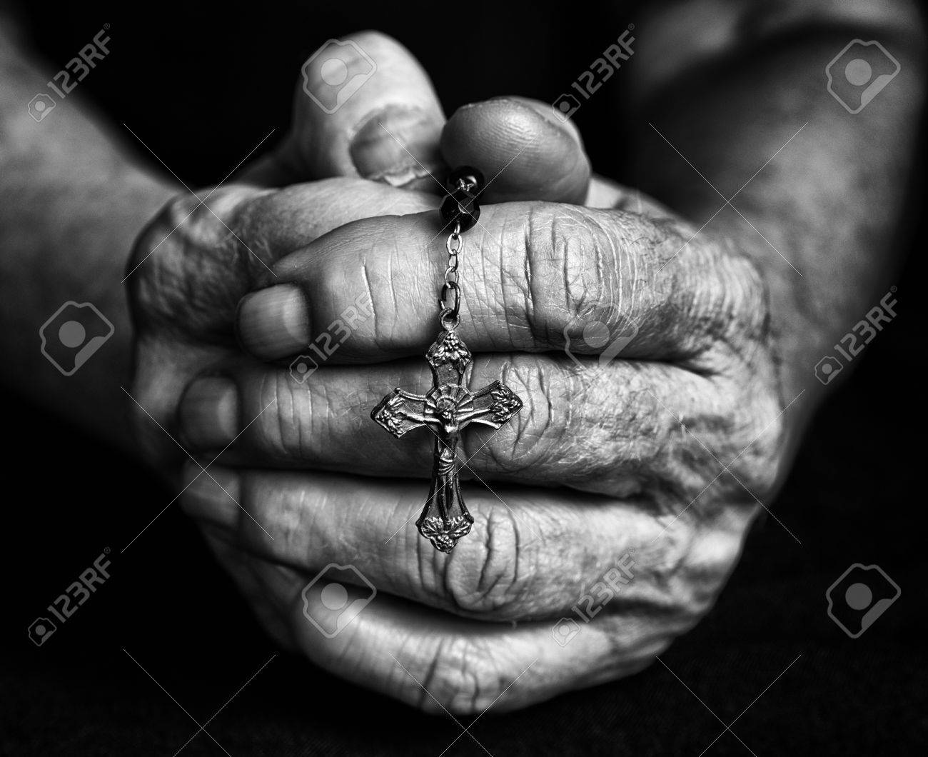 Rosary in old closed hands together black and white fotography stock photo 72969393