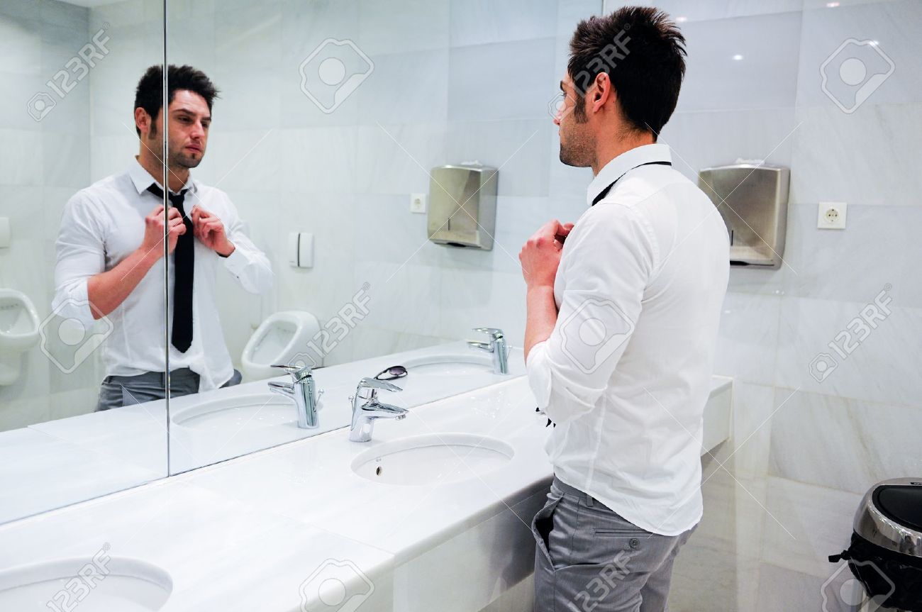Public Bathroom Mirror man getting dressed in a public restroom with mirror stock photo Public Bathroom Mirror man getting dressed in a public restroom with mirror stock photo