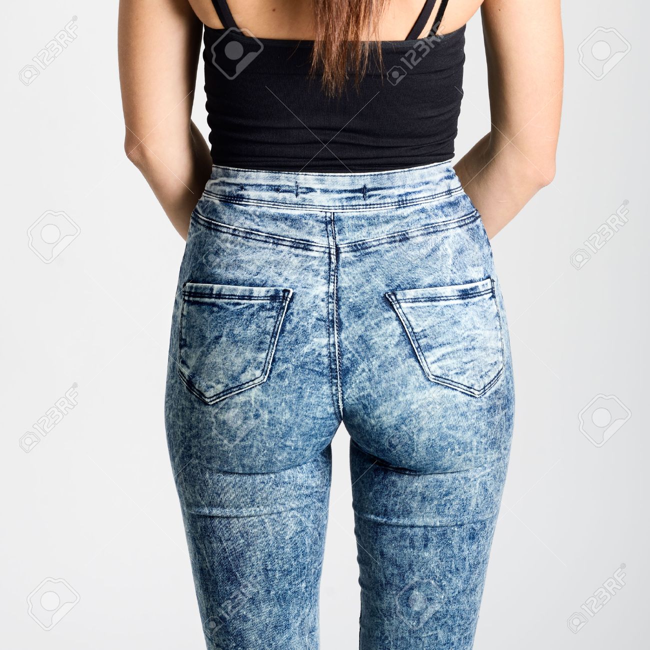 Back side of woman wearing high-waisted jeans. Studio shot. Girl with on white background - 51805096 Back side of woman wearing high-waisted jeans. Studio shot. Girl with on white background - 51805096