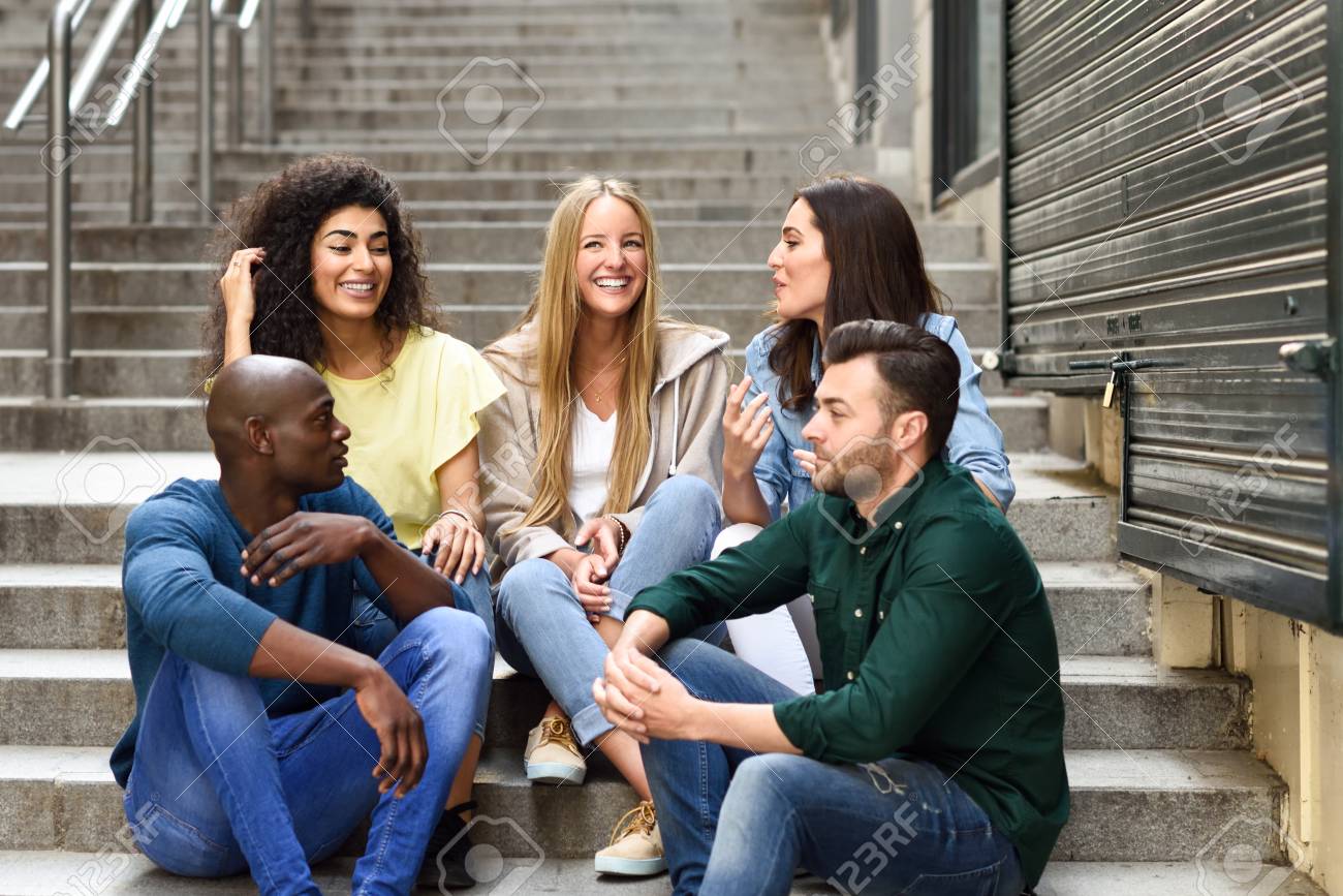 Multi-ethnic Group Of Young People Having Fun Together Outdoors In Urban  Background. Group Of Men And Woman Sitting Together On Steps. Stock Photo,  Picture And Royalty Free Image. Image 88072479.