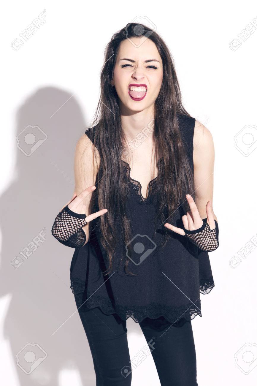 Cool swag girl in black clothes, making the sign of the horns,..