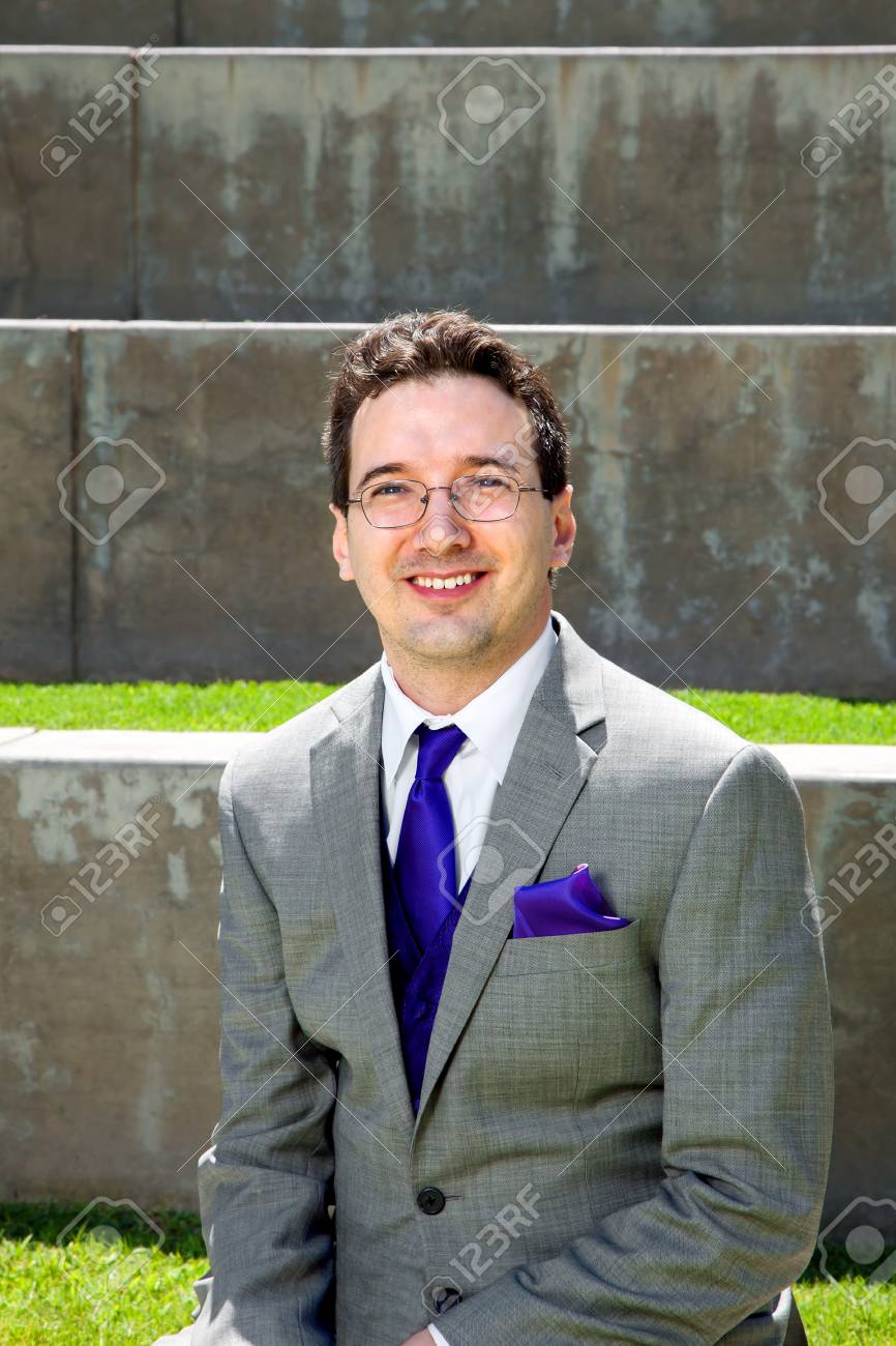 新郎は彼の結婚式の日に外に座っています 彼は紫のネクタイとハンカチとグレーのスーツを着ています の写真素材 画像素材 Image 5904