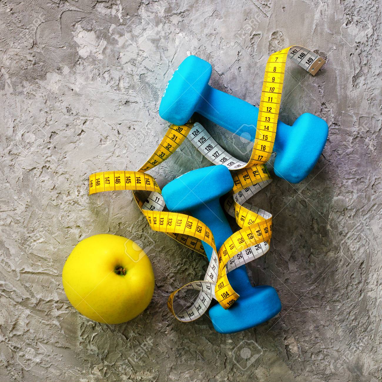 測定テープとコンクリートの背景に黄色のリンゴと古いダンベル テキストの無料スペース スポーツ コンセプト の写真素材 画像素材 Image