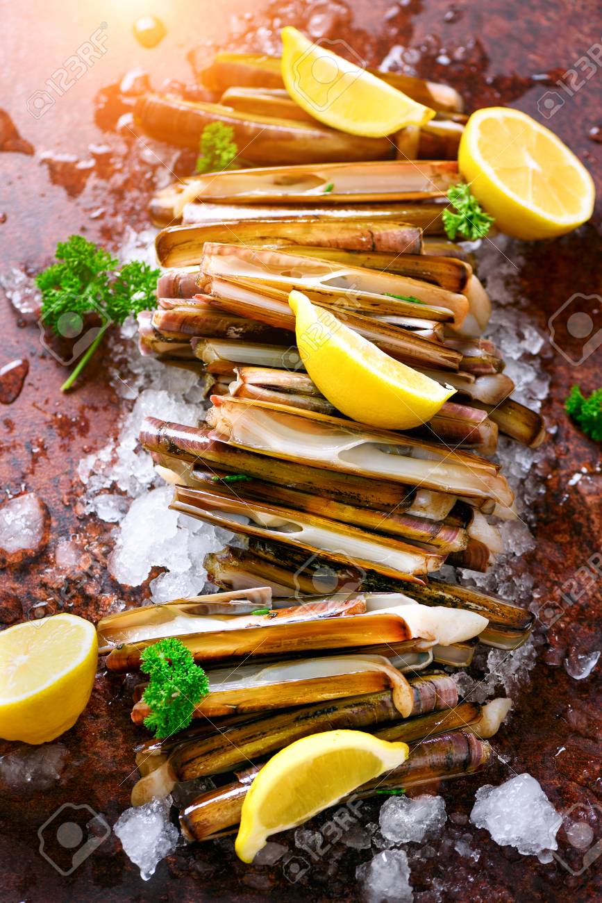 バンドル 氷の上に新鮮なカミソリのアサリの束 暗いコンクリートの背景 レモン ハーブ コピー領域 上面図 の写真素材 画像素材 Image 89682762
