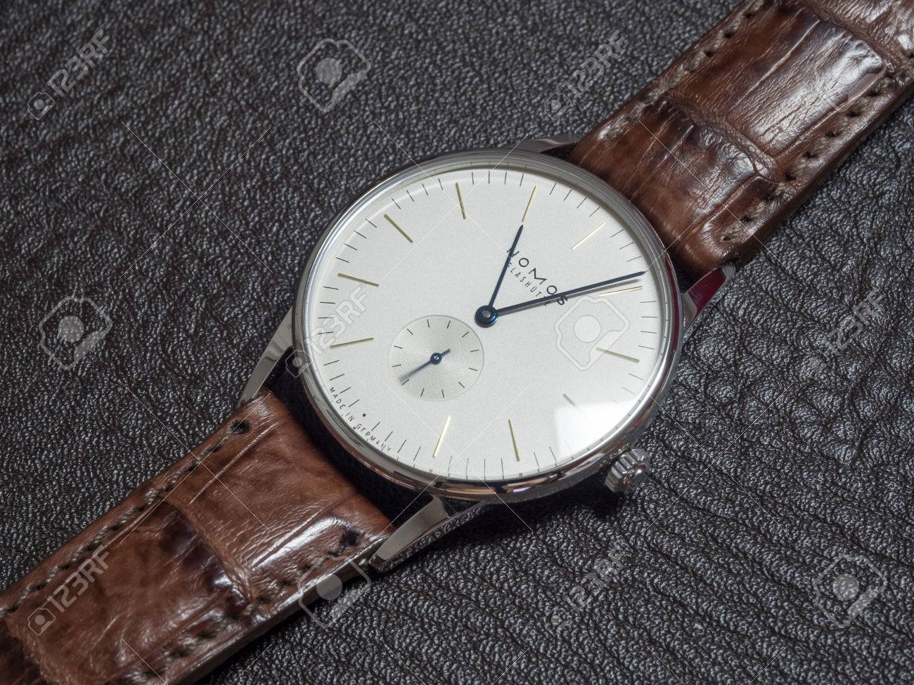 バンコク 2 月 5 日 ノモスの時計はドイツの時計ブランド シンプルなクリアでクリーンなデザイン 巻線機 ホワイト ダイアル ブラウンのアリゲーター ストラップの高級腕時計と卓越しました の写真素材 画像素材 Image