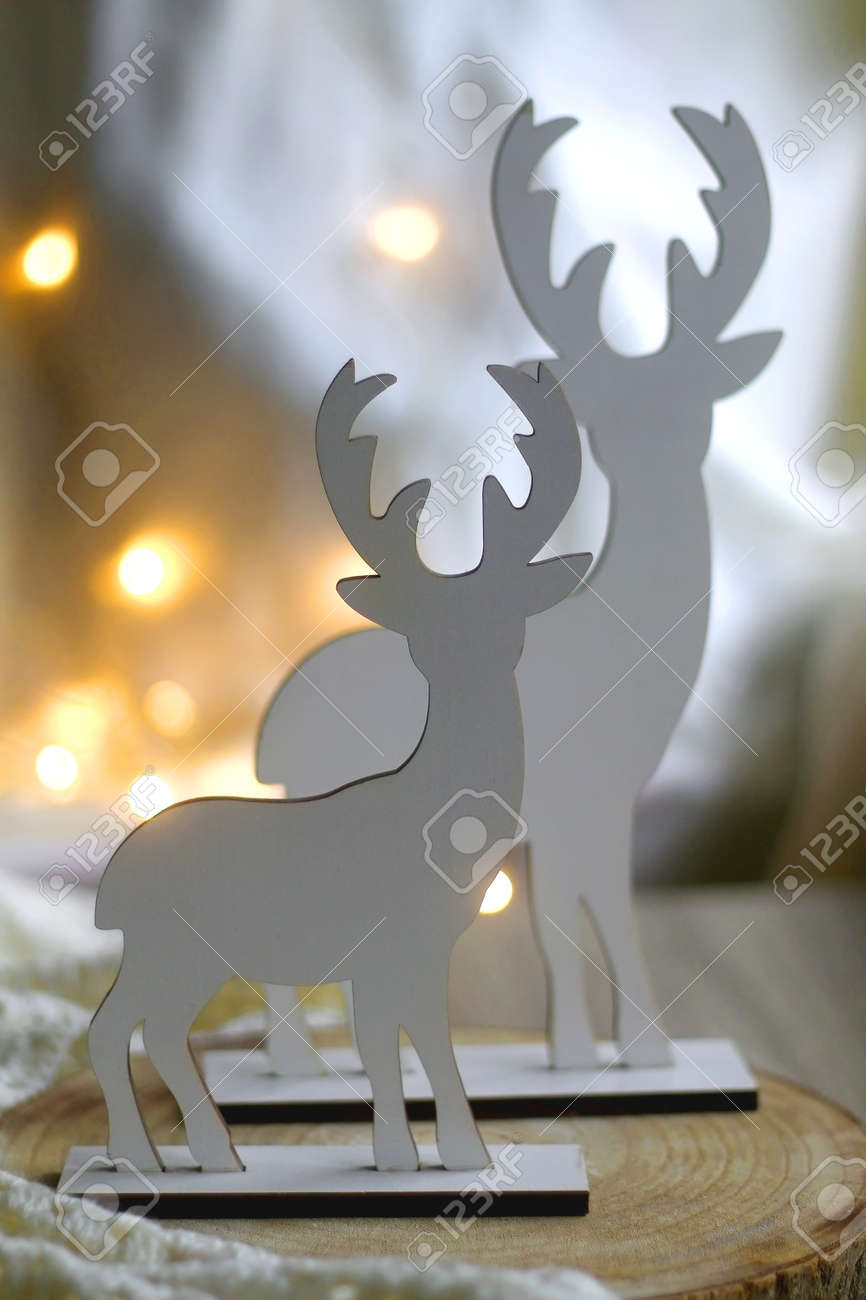 2つの木製のトナカイの置物と背景のボケライト。セレクティブ