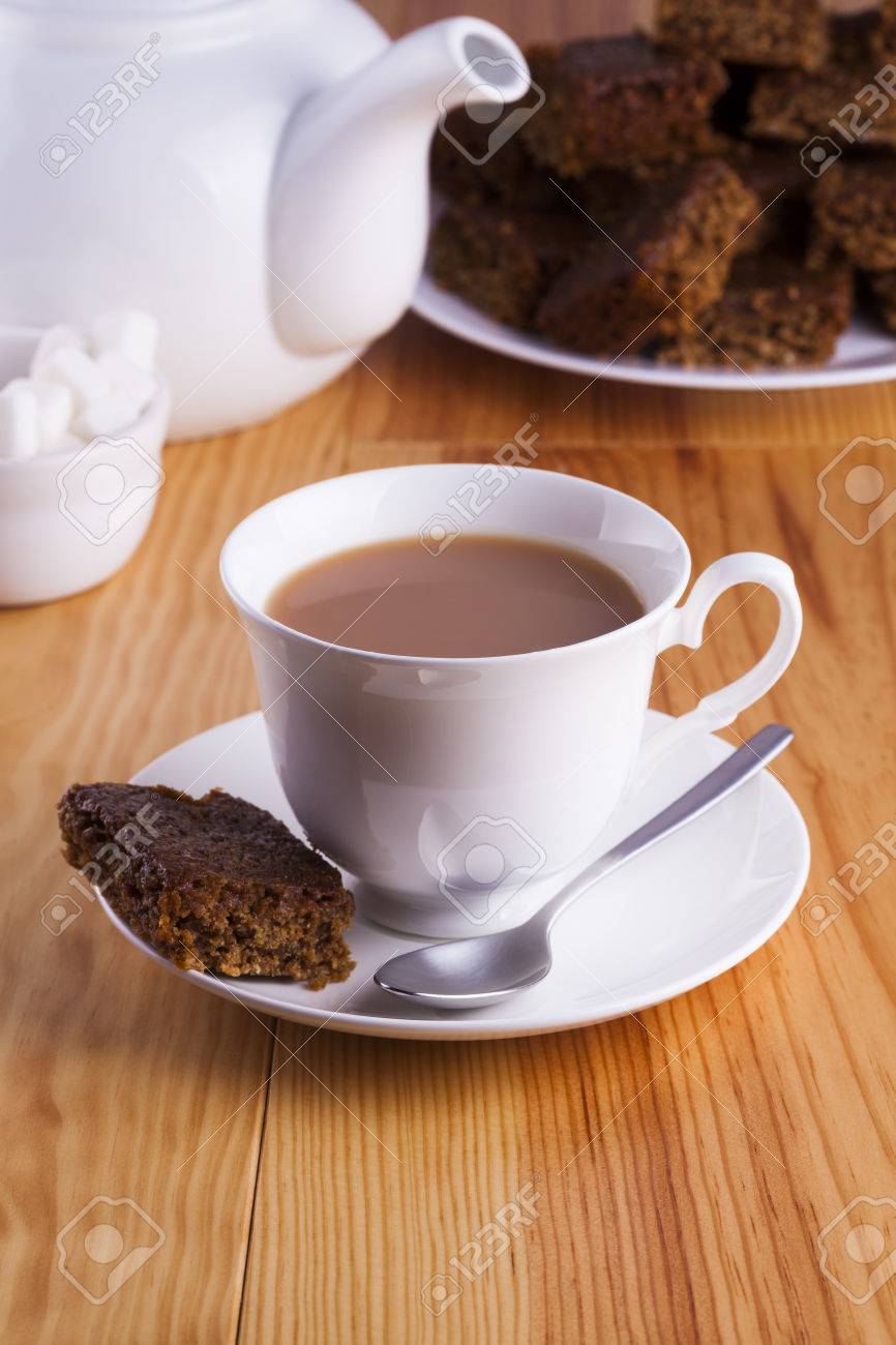 銀のスプーンと角砂糖のボウルの午後のお茶の時間のためのケーキと紅茶のカップ の写真素材 画像素材 Image