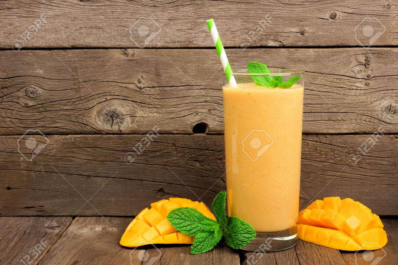 グラスにミントと素朴な木の背景にわら健康マンゴー スムージー の写真素材・画像素材. Image 77066594.