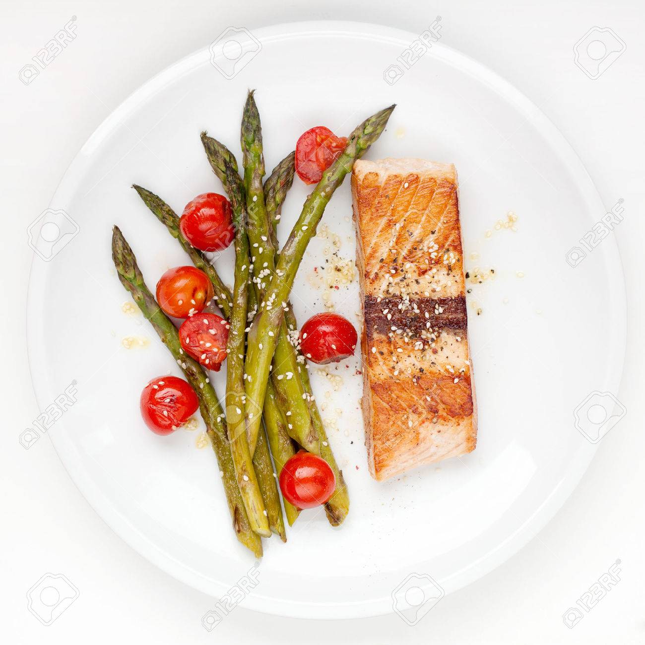 Salmon fillet with asparagus and cherry tomatoes on white plate - 27939939 Salmon fillet with asparagus and cherry tomatoes on white plate - 27939939
