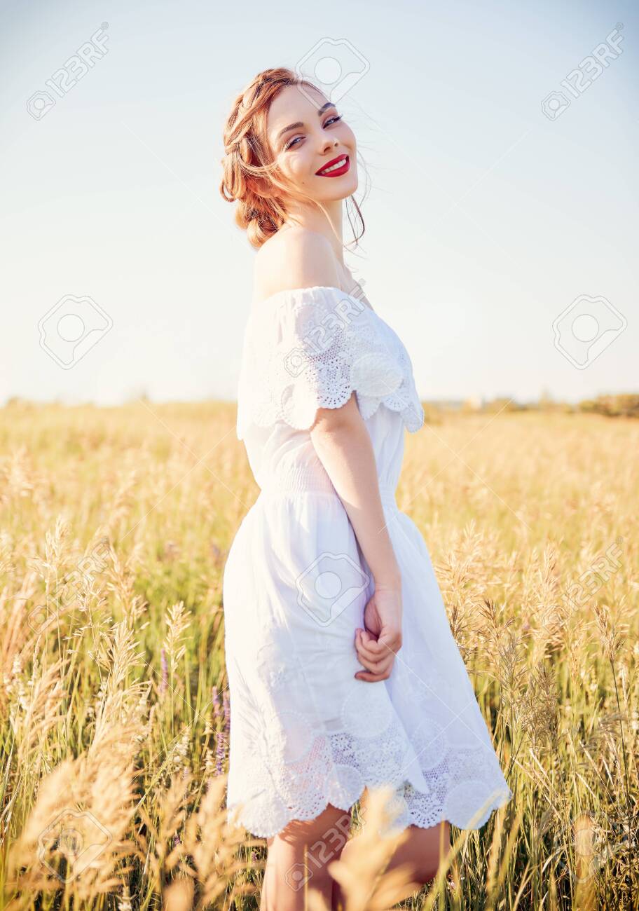 Portrait of sweet young smiling girl wearing white dress in a meadow - 123519429 Portrait of sweet young smiling girl wearing white dress in a meadow - 123519429