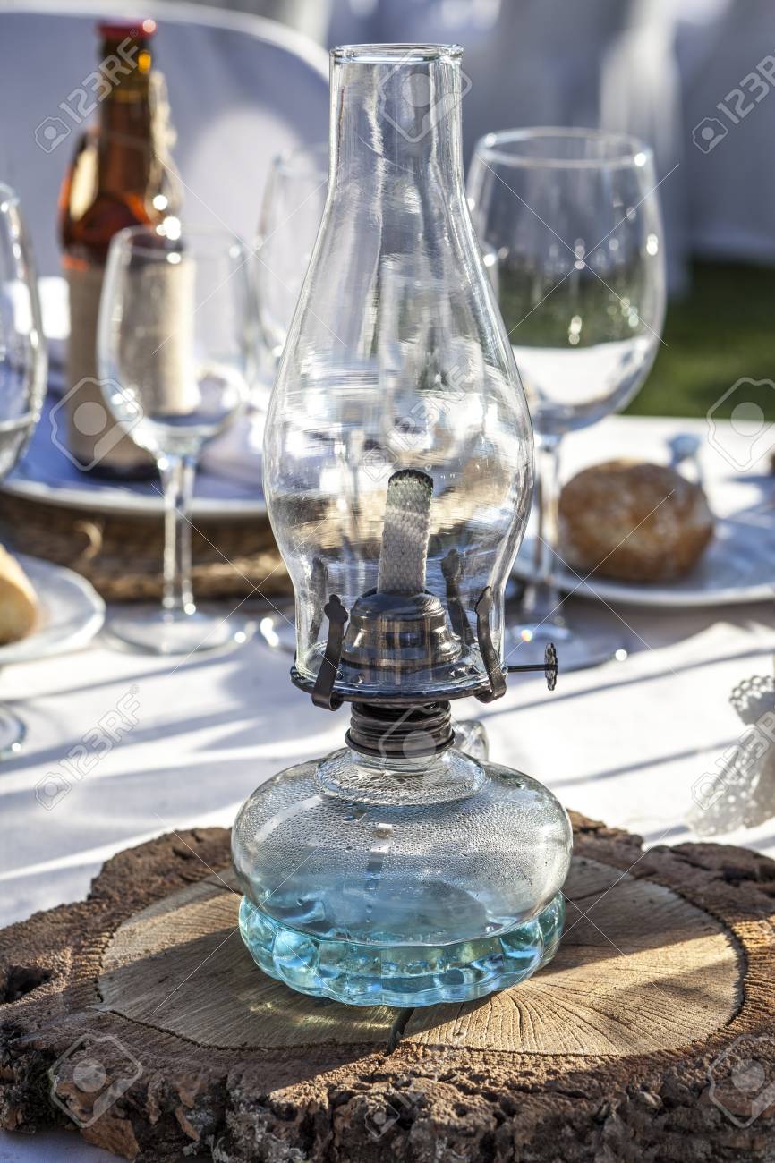 Rustic Kerosene Lamp Over Log Cut As A Wedding Centerpiece Table
