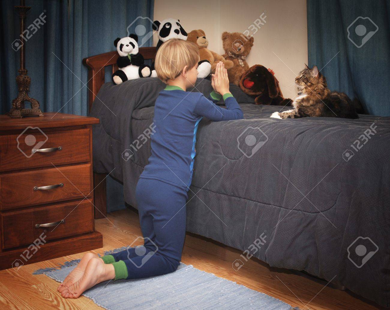 16947911-boy-kneeling-at-bedside-saying-prayers-in-pajamas.jpg