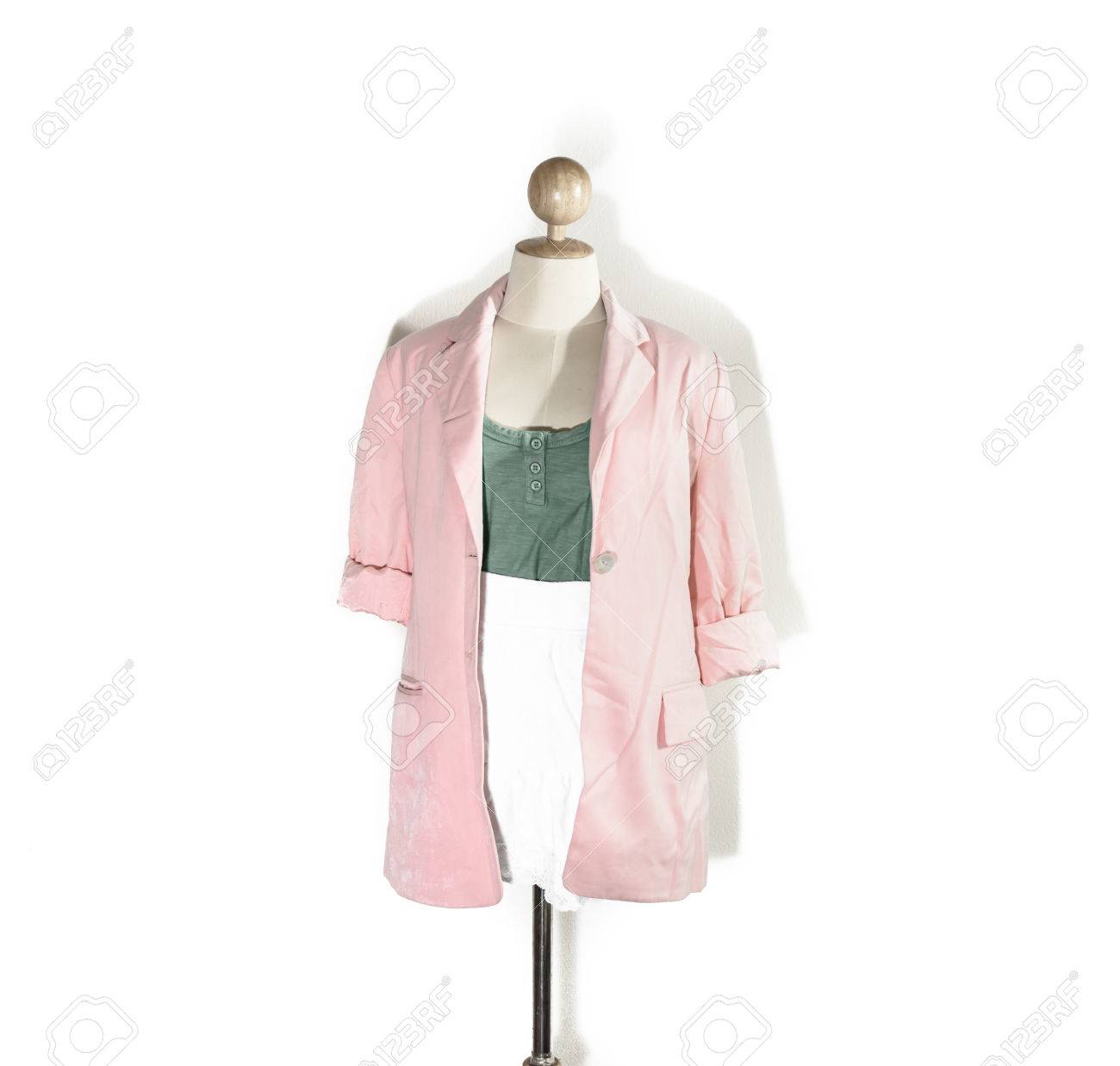 Close up normale oude dame groen vest en witte korte jurk met roze shirt geïsoleerd op een witte achtergrond Close up normale oude dame groen vest en witte korte jurk met roze shirt geïsoleerd op een witte achtergrond