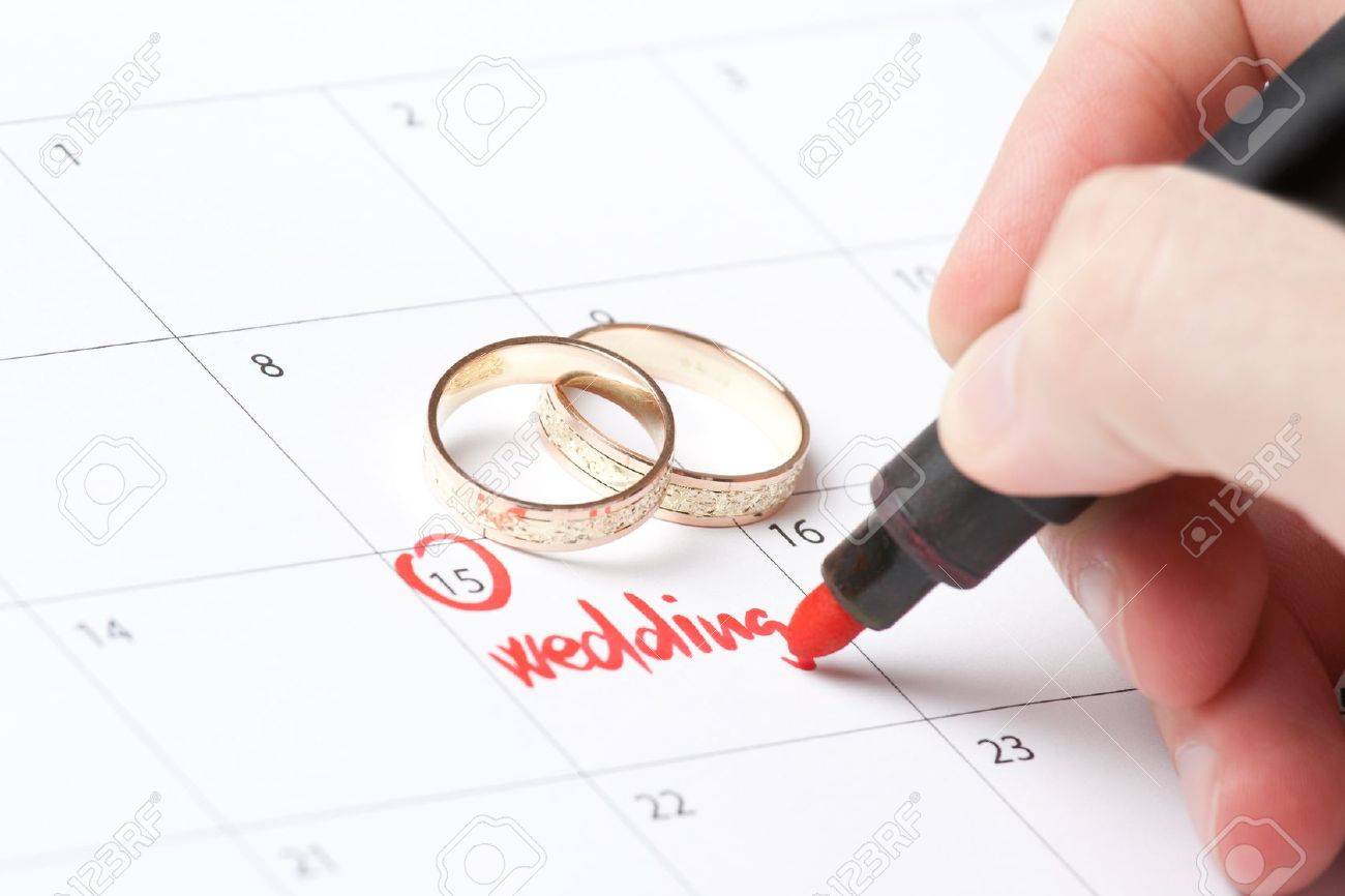 wedding rings and hand writing word wedding into calendar stock