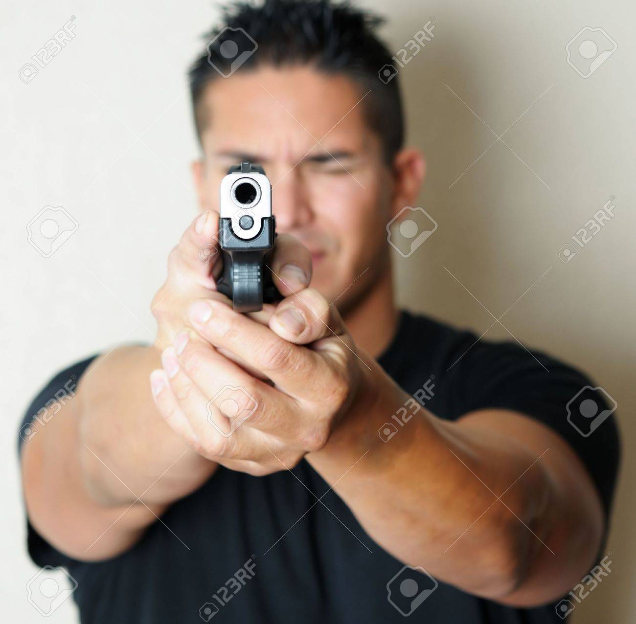8281162-image-of-young-male-pointing-gun-focus-on-barrel-of-gun-.jpg