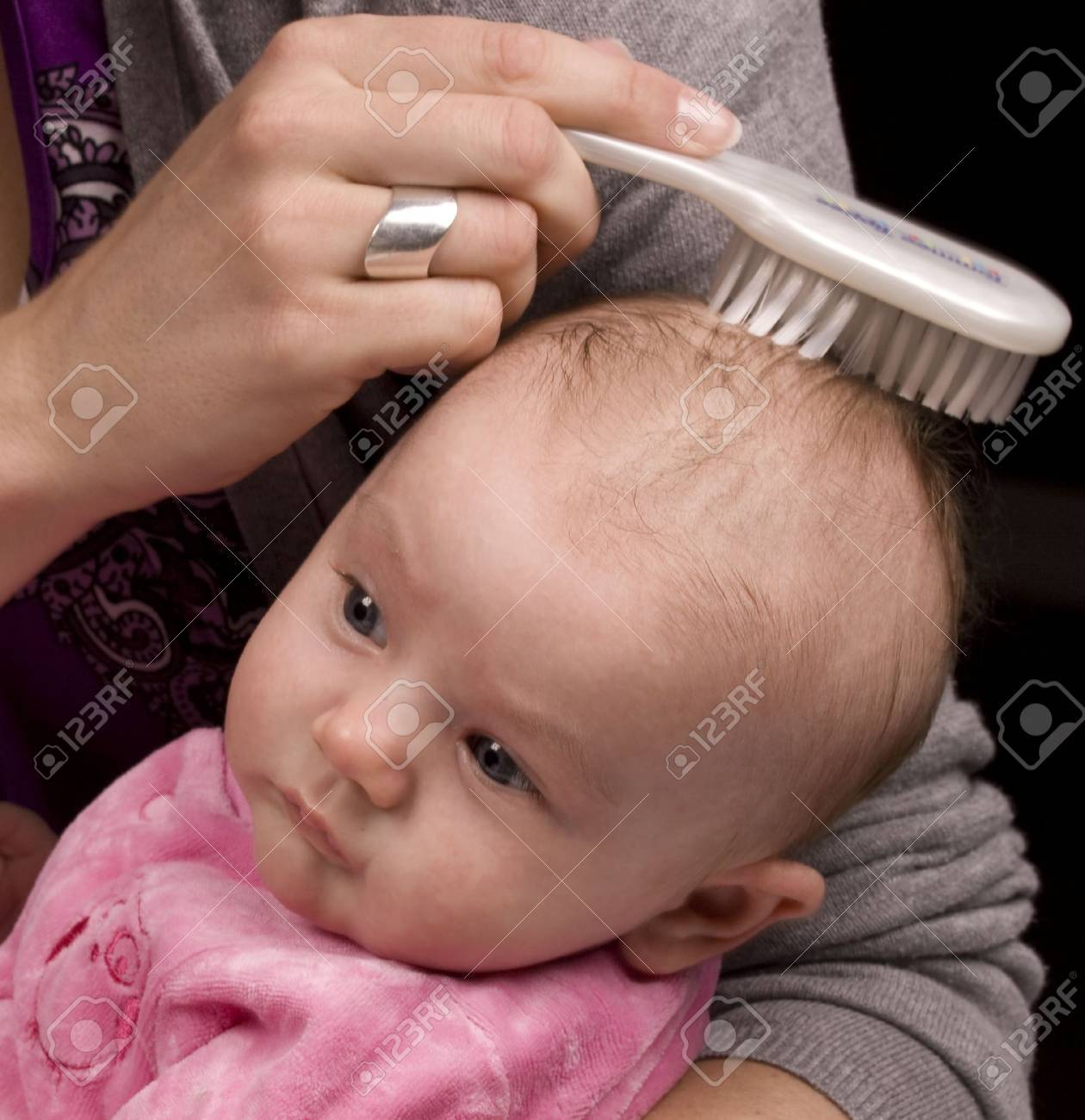 Mother brushing her daughter 's hair with a white brush. - 5562922 Mother brushing her daughter 's hair with a white brush. - 5562922