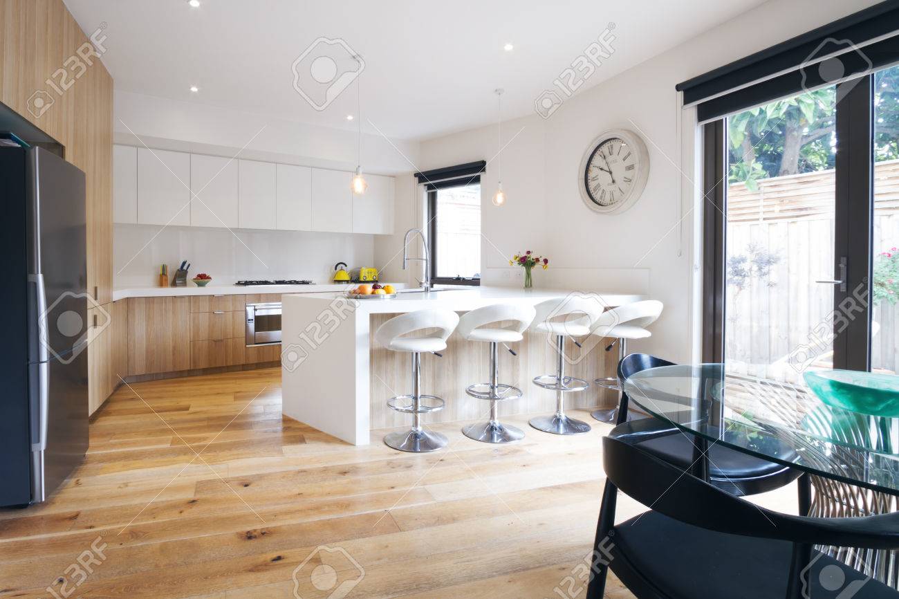 Modern open plan kitchen with island bench and bar stools stock ...