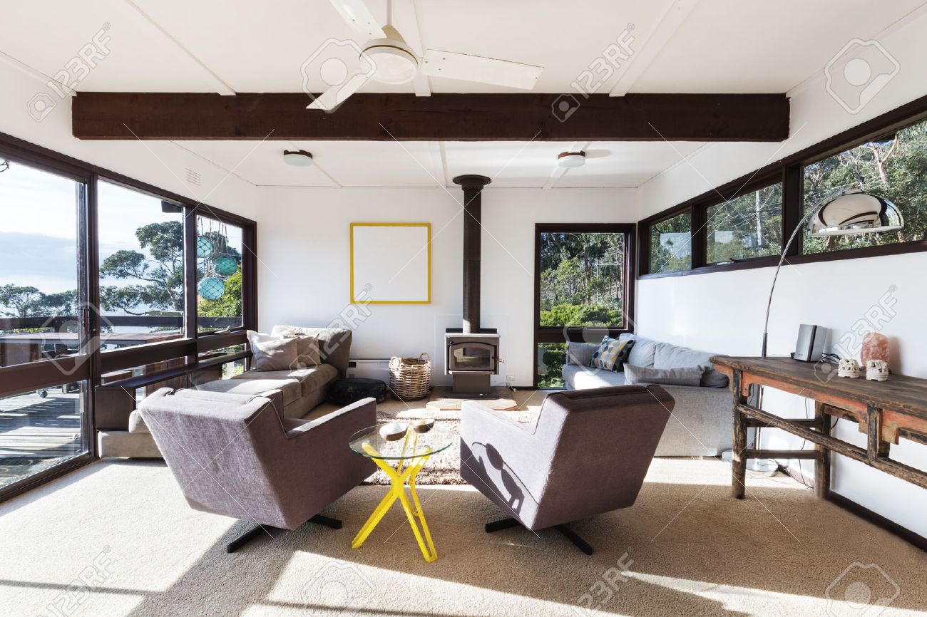 Funky retro beach house living room with 70s style recliner chairs and amazing views - 63226137 Funky retro beach house living room with 70s style recliner chairs and amazing views - 63226137