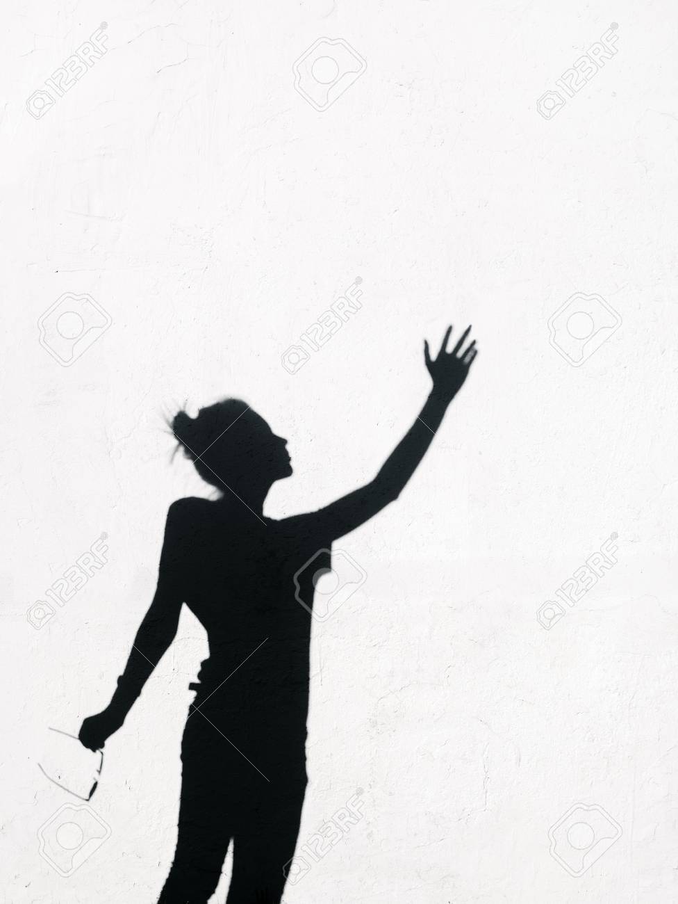 白い壁の背景の周りに空に向かって手を伸ばしてサングラスを持つ少女 の写真素材 画像素材 Image