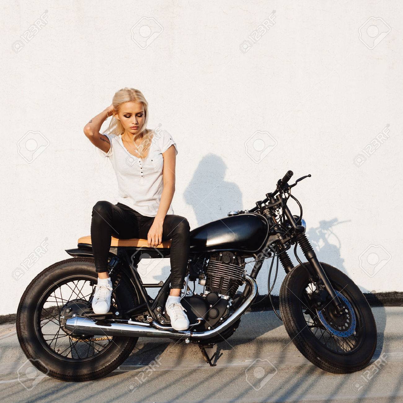 ファッション女性バイカーの女の子 レザー ジャケットをビンテージ カスタム バイクの上に座っての若いブロンドの女性 アウトドア ライフ スタイルの肖像画 の写真素材 画像素材 Image