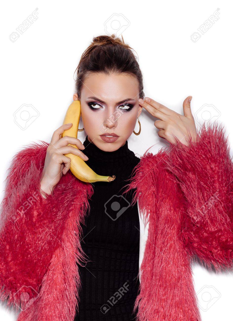 Fashion swag girl wearing black dress and pink fur coat making..