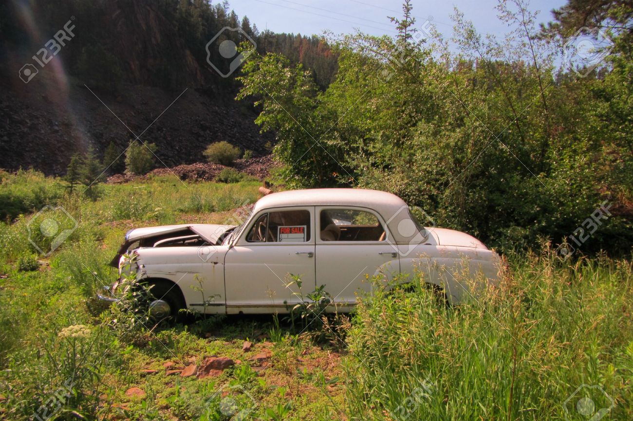 old abandoned car in ditch with a for sale sign in the window stock for sale signs for cars