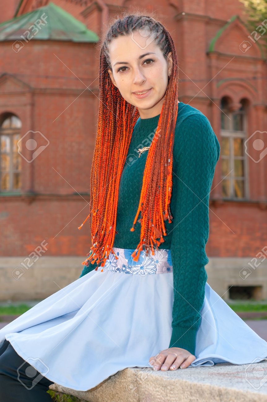 Portriat of young woman with orange braids. Girl with long red..