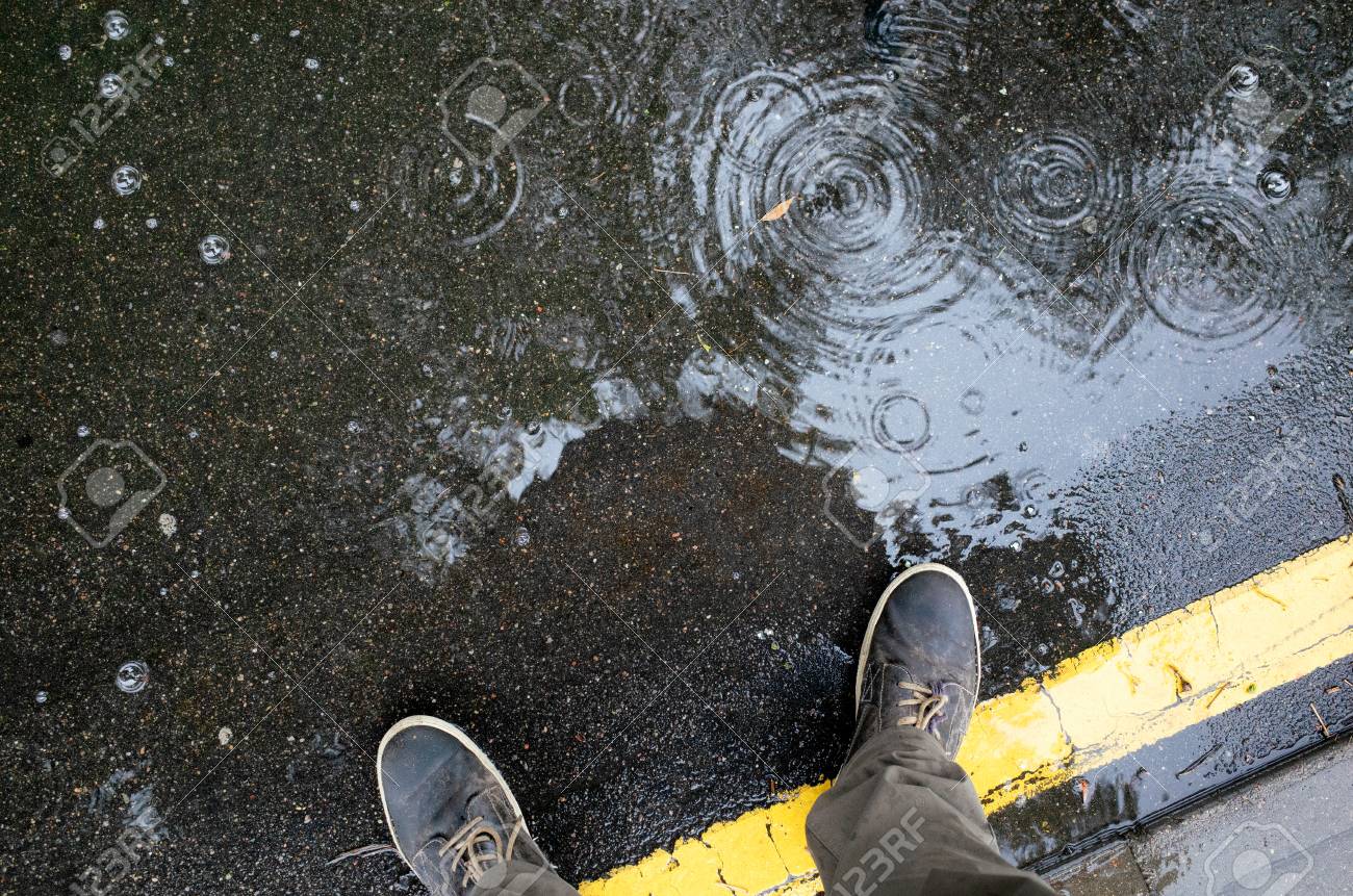 Rainy Weather Male Legs In Sneakers Or Boots Walking Through