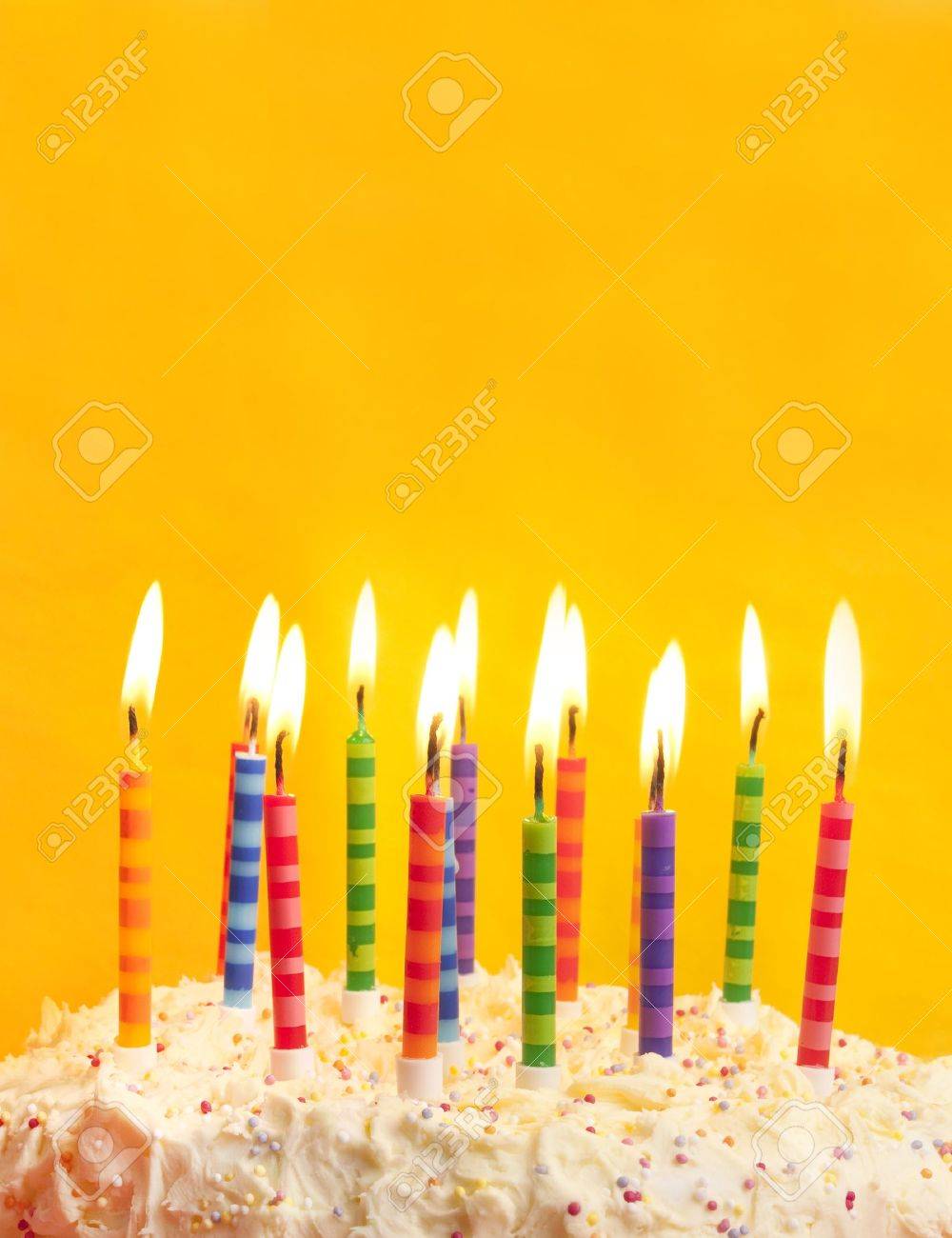 Happy Birthday Cake Shot On A Yellow Background With Candles