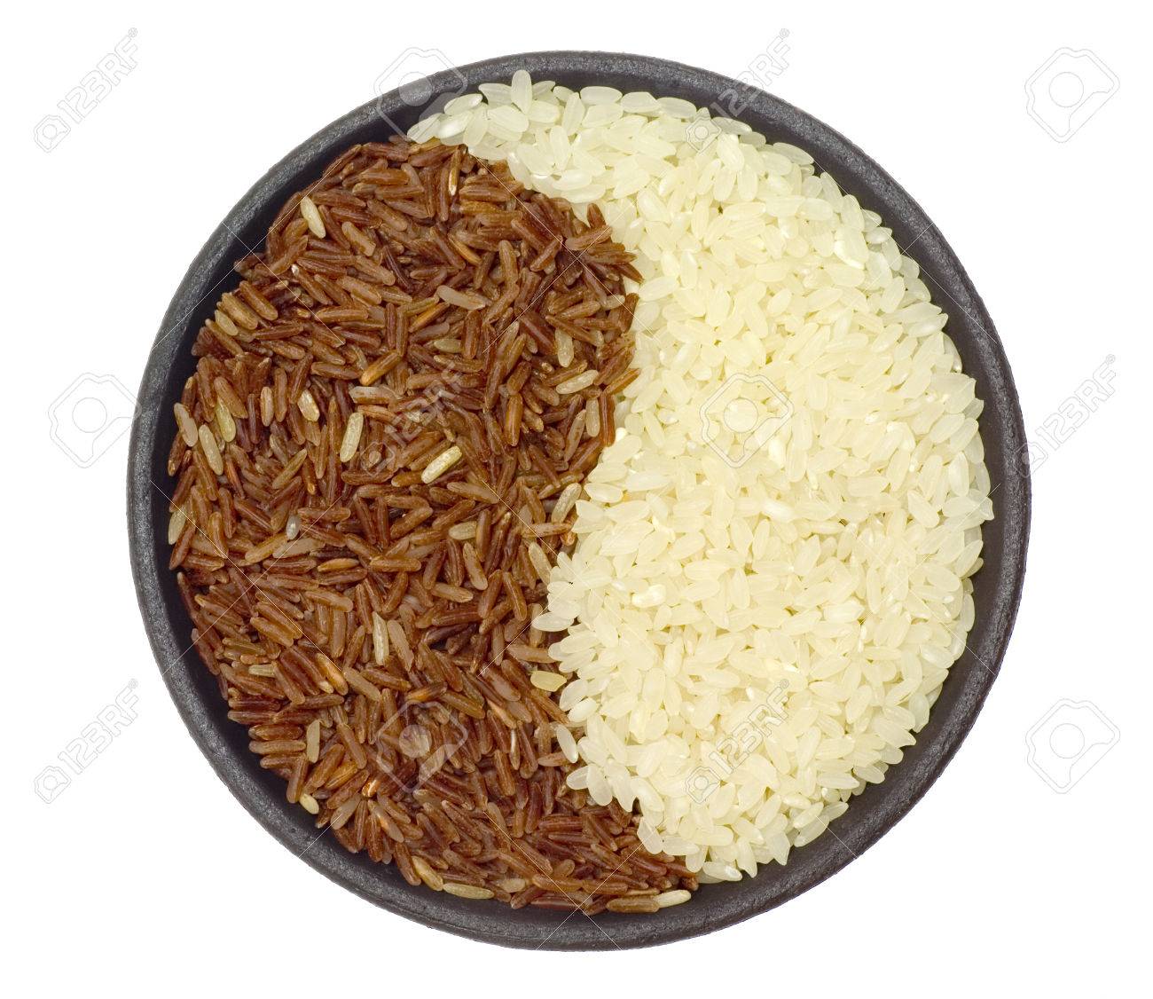 bowl of brown and white rice forming a yin yang pattern stock photo