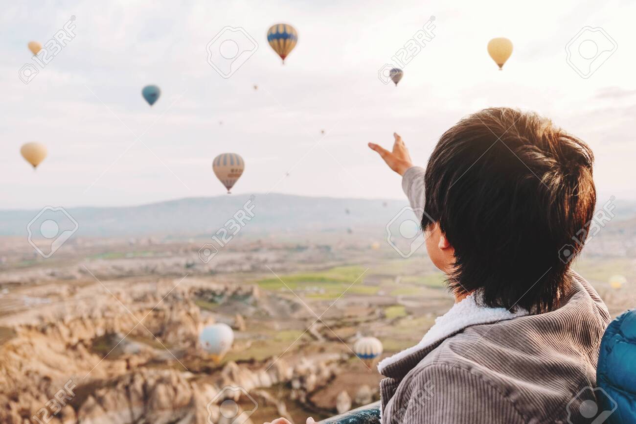 Asian man watching colorful hot air balloons flying over the valley at Cappadocia, Turkey This Romantic time - 137054510 Asian man watching colorful hot air balloons flying over the valley at Cappadocia, Turkey This Romantic time - 137054510