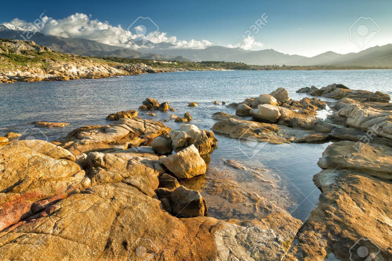 Les Roches à Arinella Plage Près De Lumio En Balagne Corse Avec Des Montagnes Enneigées Au Loin
