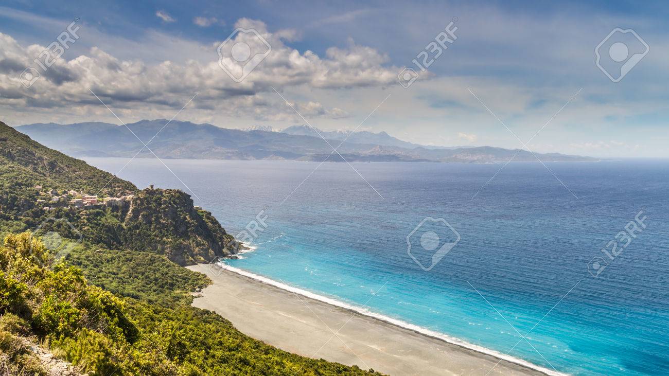 La Plage De Sable Noir Et Le Village De Nonza Sur Le Cap Corse En Corse Avec Désert Des Agriates En Arrière Plan