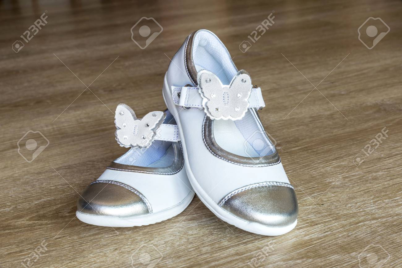Par De Blancos Para Niña Con Adornos En Forma De Mariposa En Suelo De Madera Fotos, Retratos, Imágenes Y Fotografía De Archivo Libres De Derecho. 60382854.