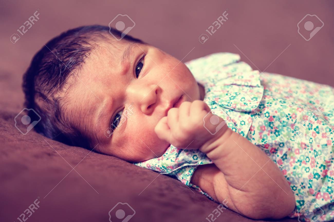 横になって 目を開いていると花柄のドレスを着て周りを見てかわいい 2 週間前新生児女の子の肖像画間近します の写真素材 画像素材 Image