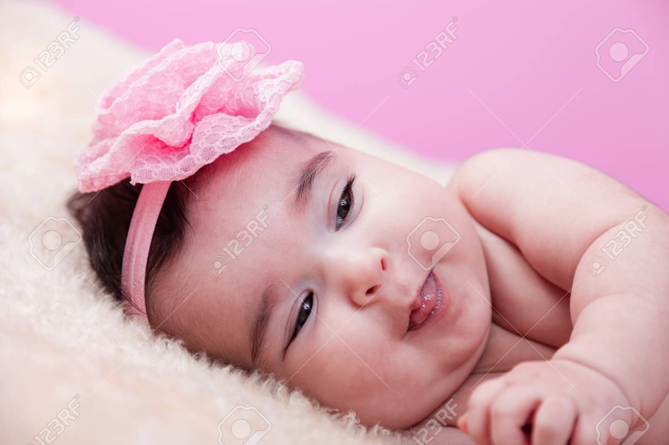 Mignon Joli Heureux Joufflu Bebe Fille Portrait Souriant Et Ludique Langue Collante Nu Ou Nu Sur Une Couverture Moelleux Bandeau De Fleur Rose Quatre Mois Banque D Images Et Photos Libres De Droits