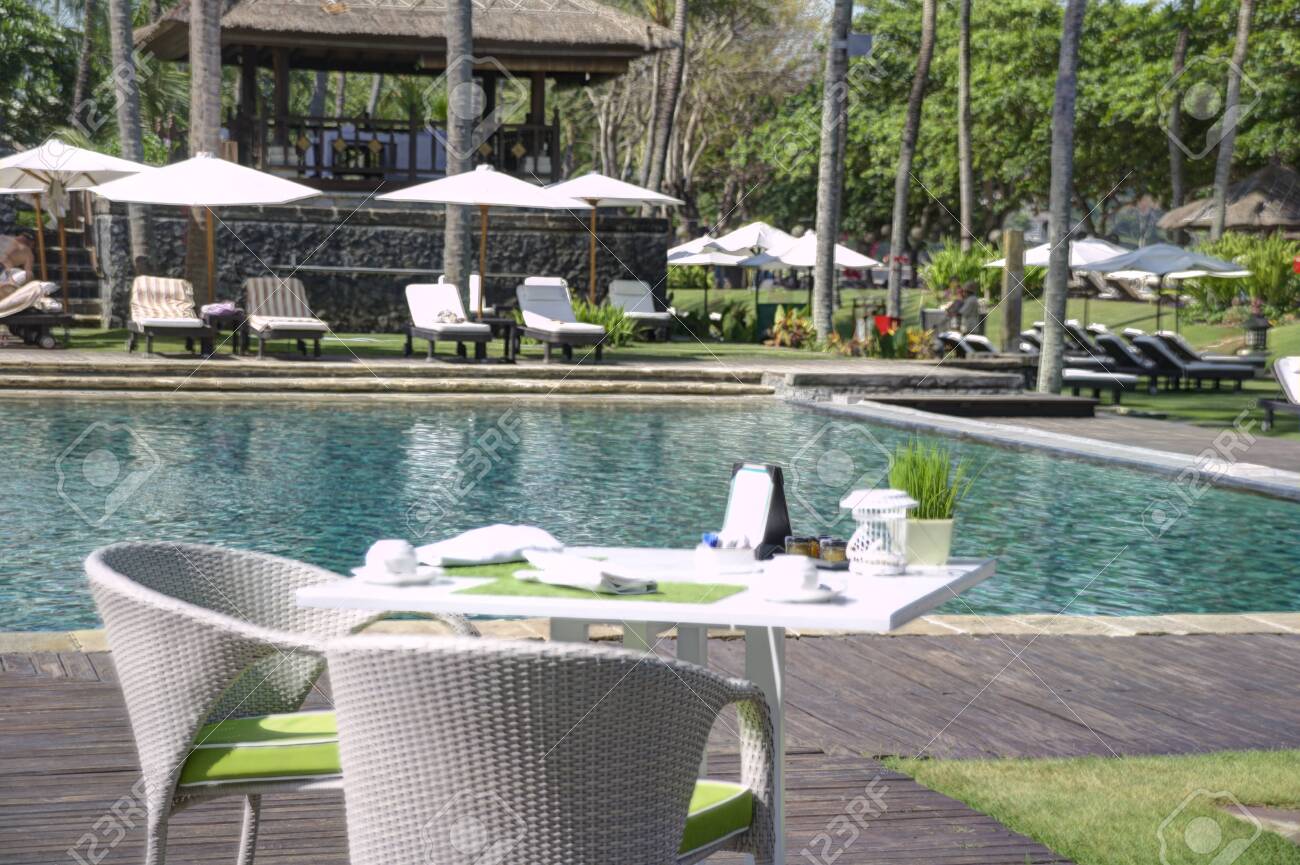 Garden Table Seating With Napkins And Tableware Beside A Swimming Stock Photo Picture And Royalty Free Image Image 135577282