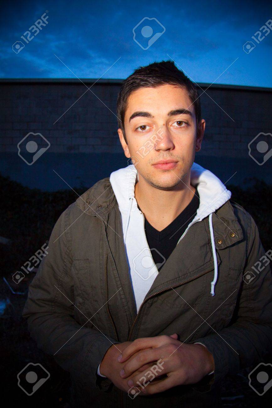 A man poses for some fashion photography at night wearing a modern..