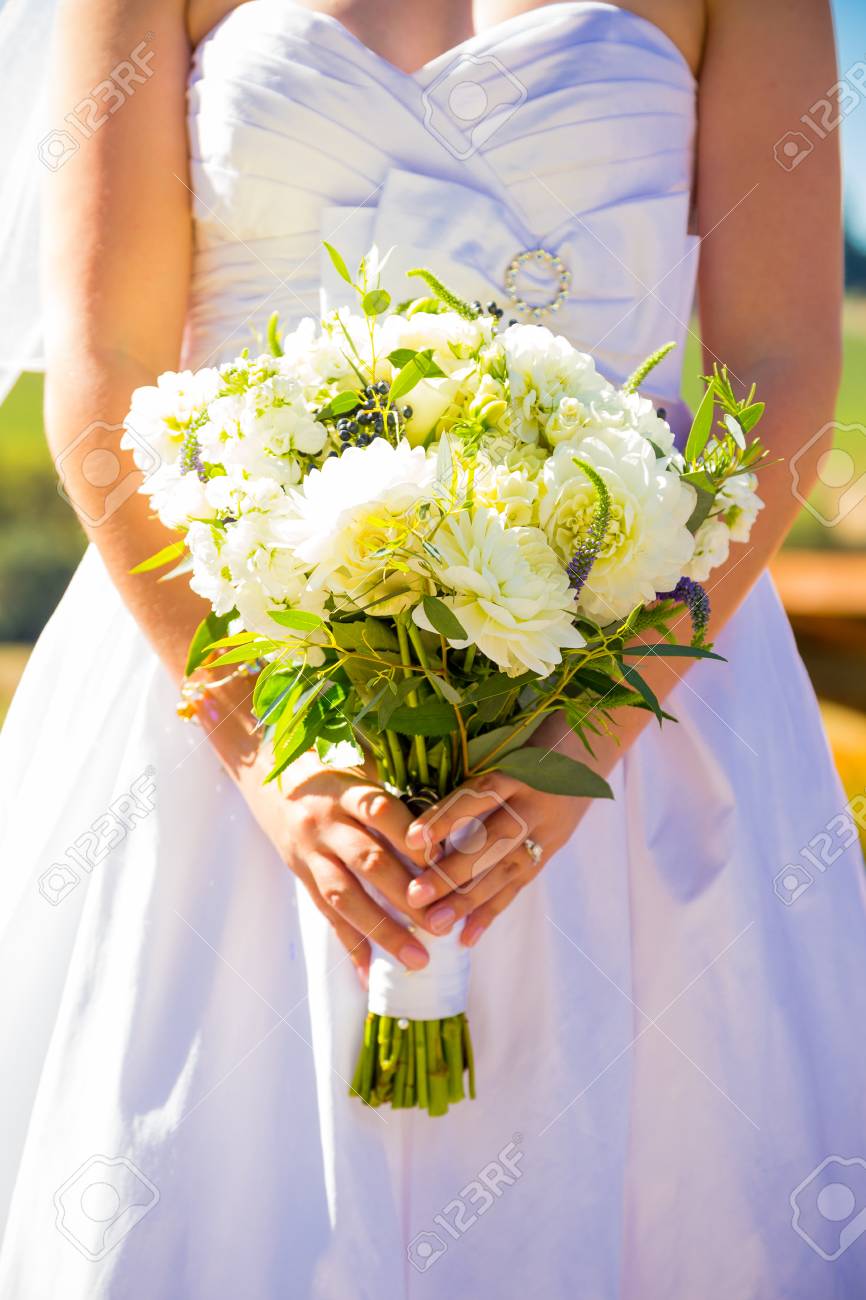 Une Jeune Mariée Dans Une Robe De Mariée Blanche Tient Son Bouquet De Fleurs Le Jour De Son Mariage