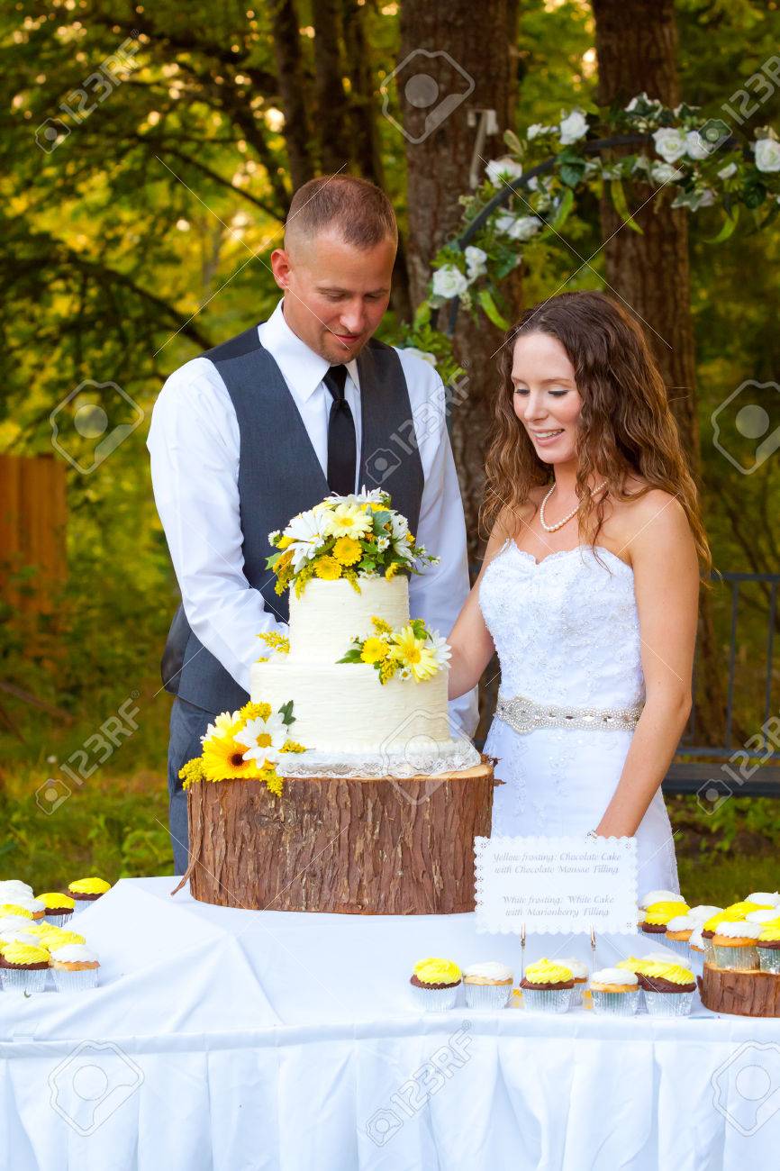 新郎新婦は、結婚式当日、フロントでのケーキカットの伝統で共有します 