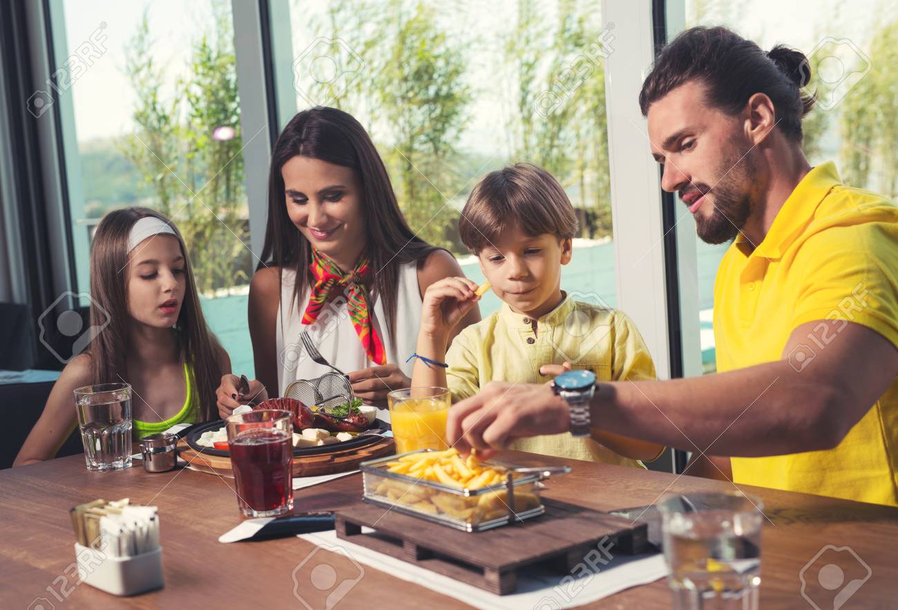 Uma Familia De Quatro Membros Que Se Diverte Em Um Restaurante Fotos Retratos Imagenes Y Fotografia De Archivo Libres De Derecho Image 85606191