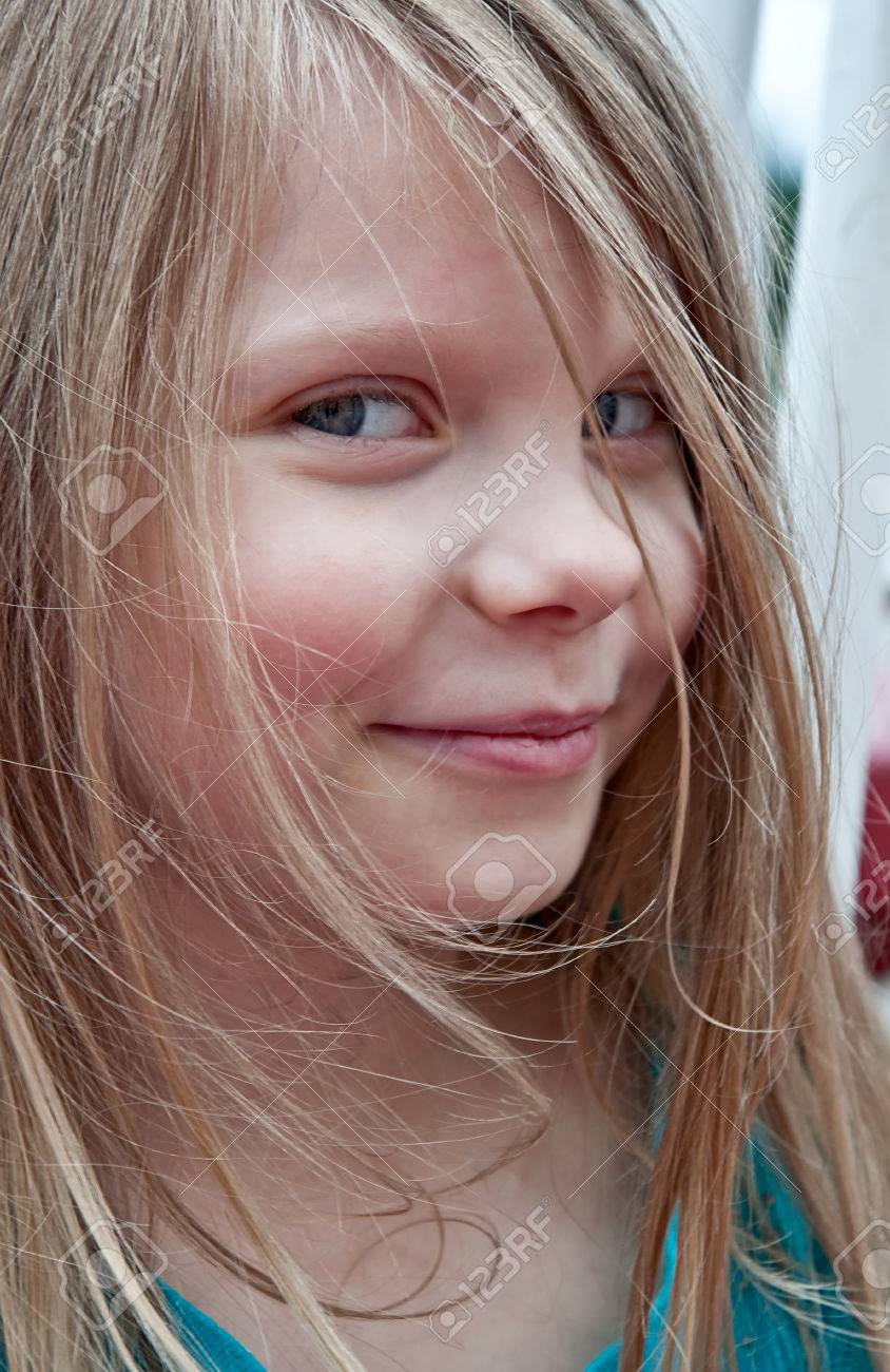 このかわいい 5 歳の少女の肖像画は彼女の顔の彼女は長いブロンドの髪とモデルは 優しく笑みを浮かべてサイドビューから白人のクローズ アップ の写真素材 画像素材 Image