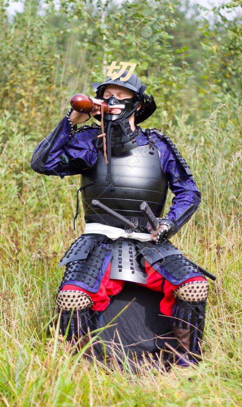 日本中世武士鎧 公立陶生具足 フラスコ茶色瓢箪 ひょうたん から屋外を飲んで座っている剣を持つ男 の写真素材 画像素材 Image