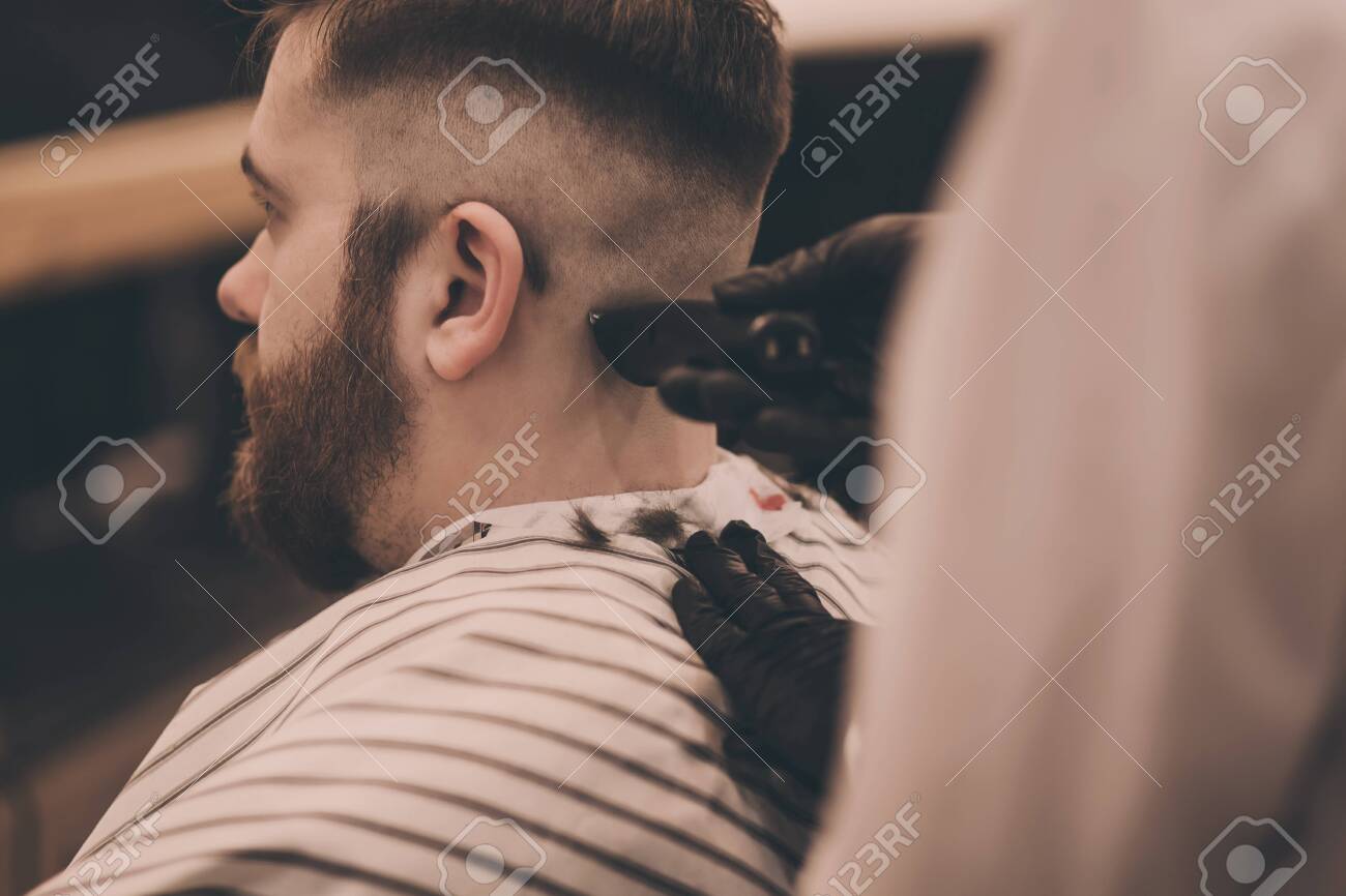 Young hipster man visiting barbershop - 140629367 Young hipster man visiting barbershop - 140629367