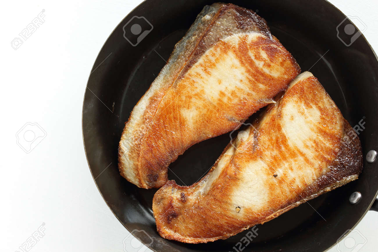Chinese food, pan fried yellow tail fish fillet in cooking pan - 169820056 Chinese food, pan fried yellow tail fish fillet in cooking pan - 169820056